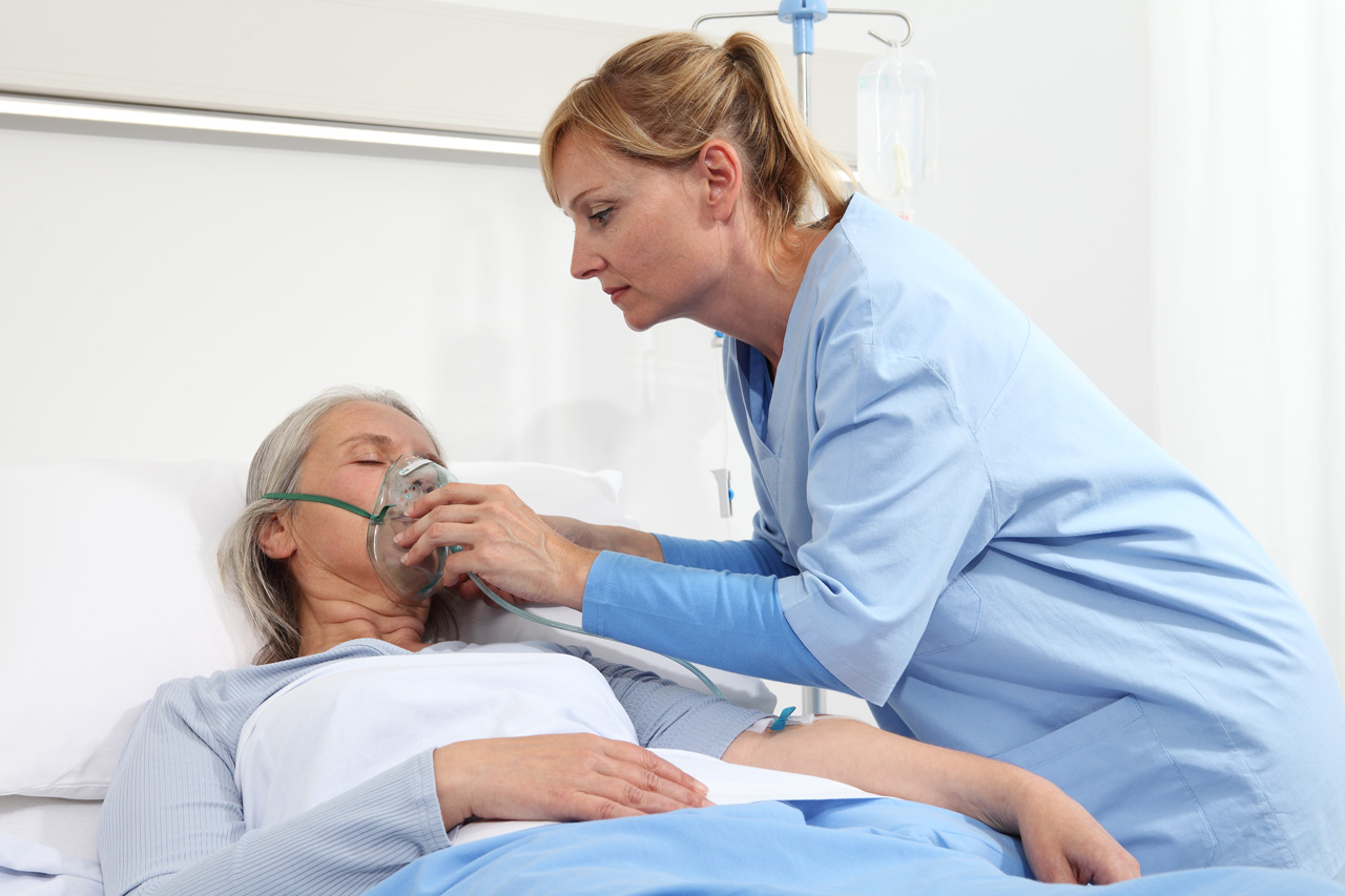 nurse-puts-oxygen-mask-on-elderly-woman-patient nurse-puts-oxygen-mask-on-elderly-woman-patient
